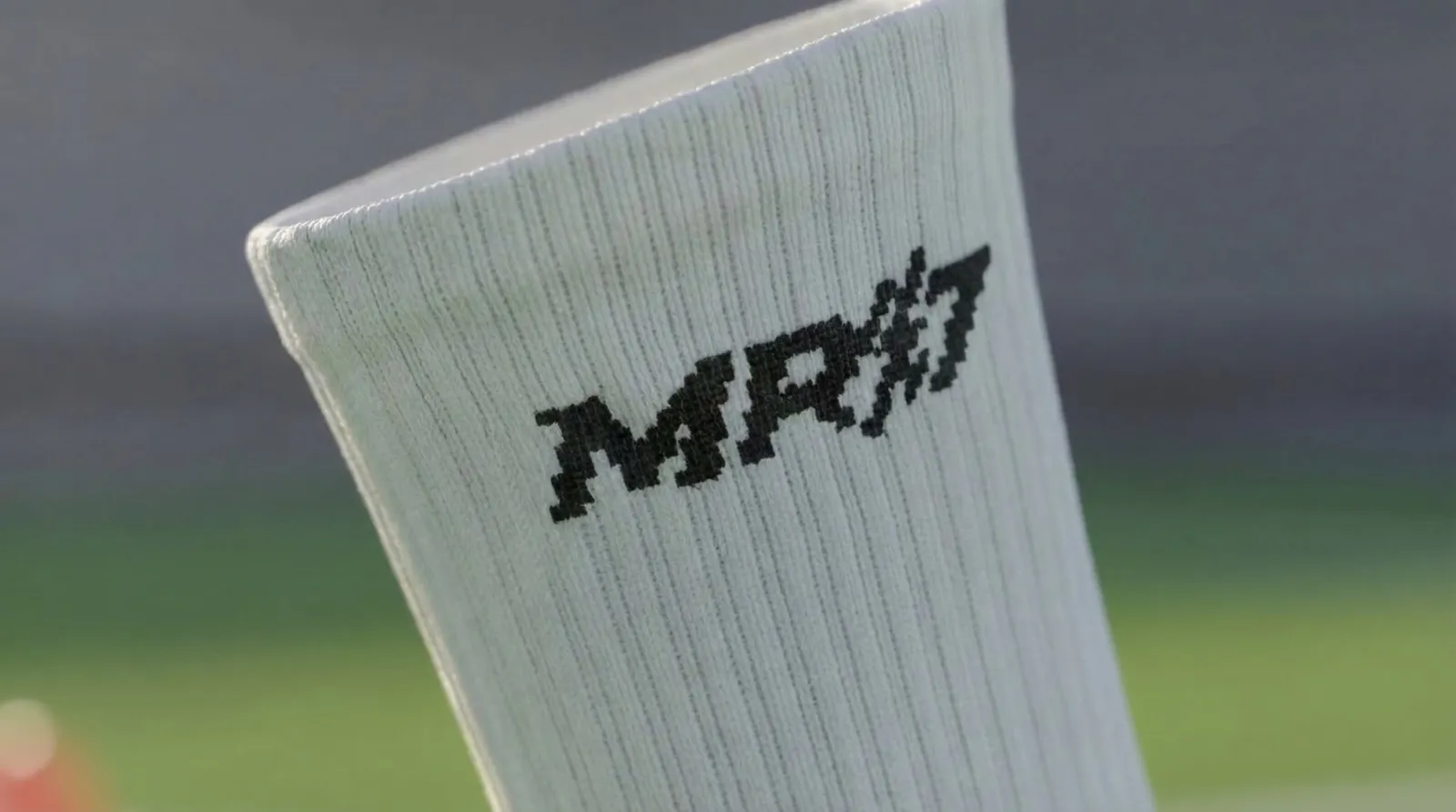 Close-up of the knitted MR7 logo on a white grip sock